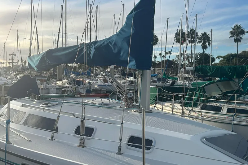 Slide: The Image of 1995 Catalina 320 sailboat cockpit with colorful ropes, docked in a marina. - 3