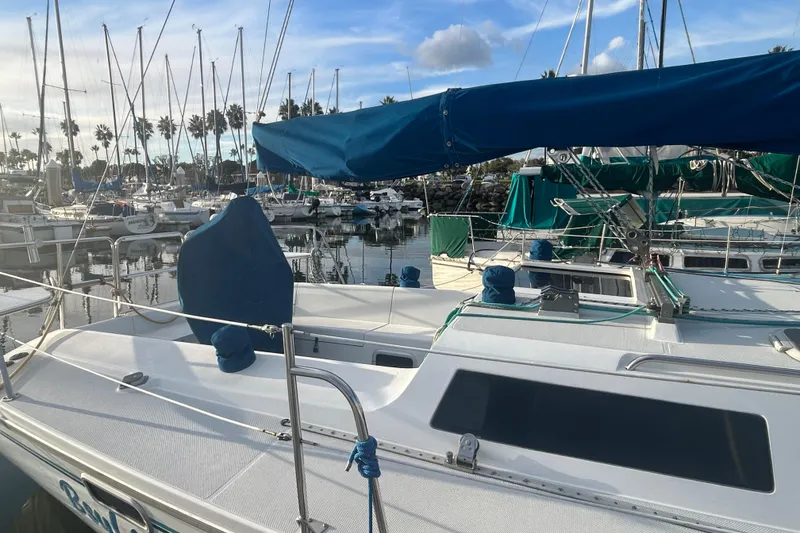 Slide: The Image of 1995 Catalina 320 sailboat docked in a marina, surrounded by other boats. - 4