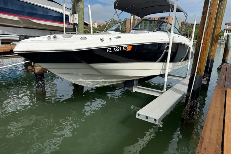 The Image of 2022 NauticStar 243 DC boat on lift at marina dock. - 1