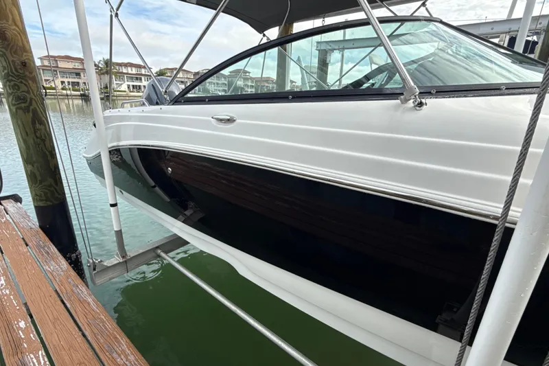 Slide: The Image of 2022 NauticStar 243 DC boat docked on a lift, with waterfront view. - 3