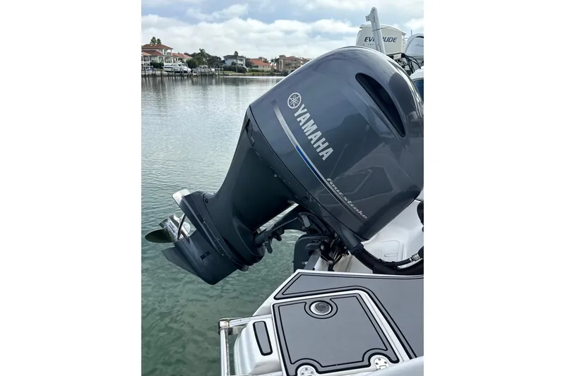 Slide: The Image of Yamaha outboard motor on 2022 NauticStar 243 DC boat, docked by waterfront homes. - 4