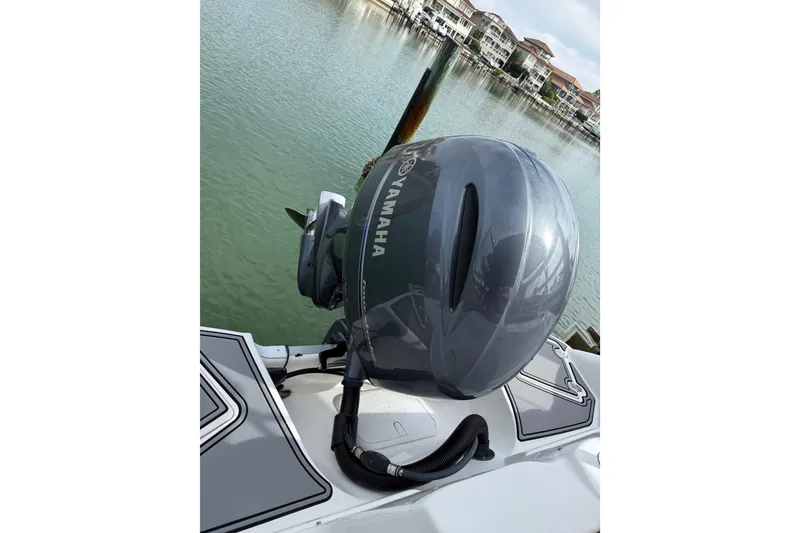 Slide: The Image of 2022 NauticStar 243 DC with Yamaha outboard motor, docked by waterfront homes. - 6