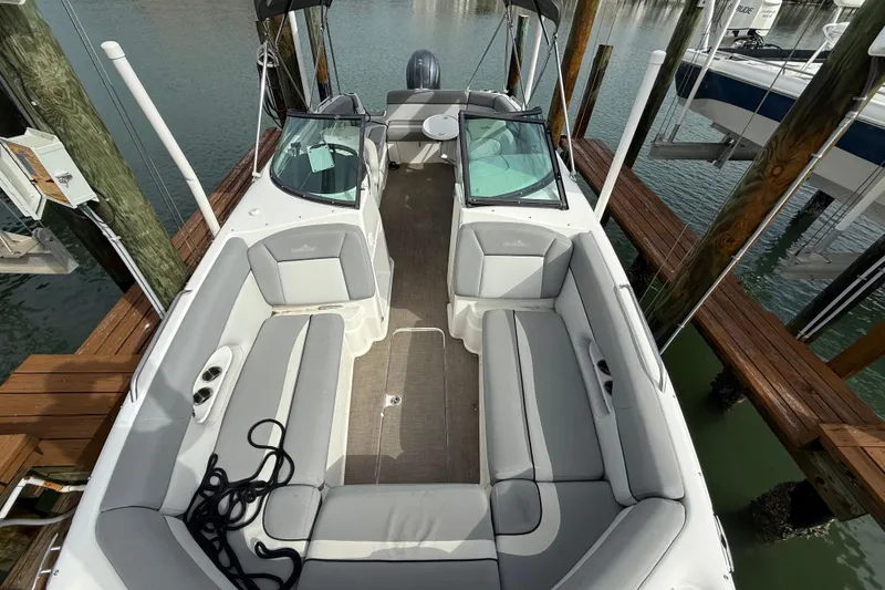 Slide: The Image of 2022 NauticStar 243 DC boat docked, featuring spacious seating and sleek design. - 8