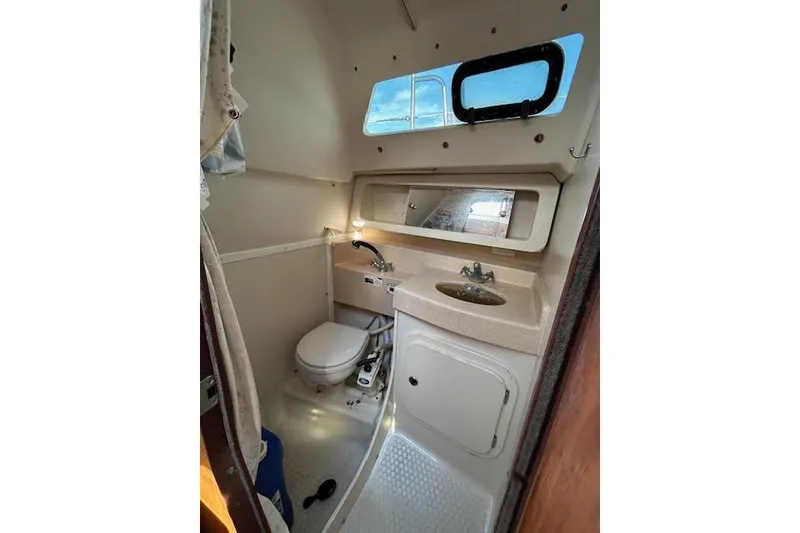 Slide: The Image of Bathroom interior of a 2003 Catalina 310 sailboat with sink, toilet, and mirror. - 11