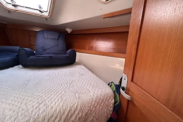 Slide: The Image of Cozy cabin interior of a 2003 Catalina 310 sailboat with a quilted bed. - 13