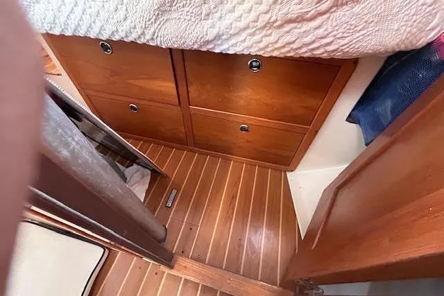 Slide: The Image of Interior of 2003 Catalina 310 sailboat with wooden flooring and storage drawers. - 14