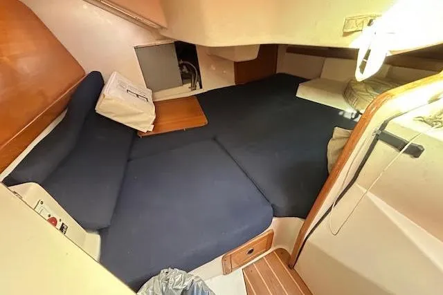 Slide: The Image of 2003 Catalina 310 sailboat interior cabin with blue cushions and wooden accents. - 6