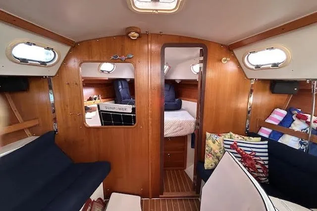 Slide: The Image of Interior of a 2003 Catalina 310 sailboat with cozy seating and wooden finishes. - 7