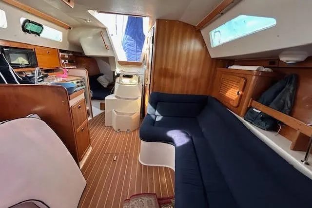 Slide: The Image of Interior of 2003 Catalina 310 sailboat with cozy seating and wooden finishes. - 8