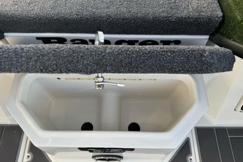 Slide: The Image of 2026 Ranger 620xFS Pro boat livewell with carpeted lid and measuring ruler. - 23