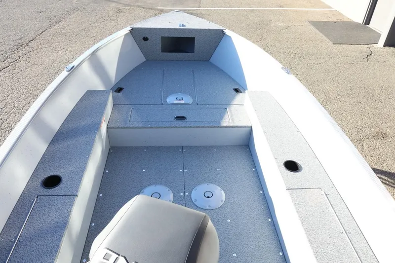 Slide: The Image of 2026 Lund 1600 Fury Tiller boat interior with gray seating and storage compartments. - 11