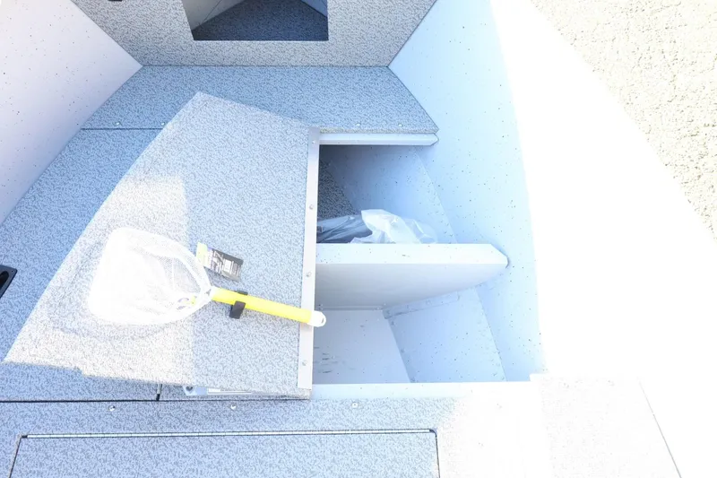 Slide: The Image of 2026 Lund 1600 Fury Tiller boat interior with storage compartment and fishing net. - 15