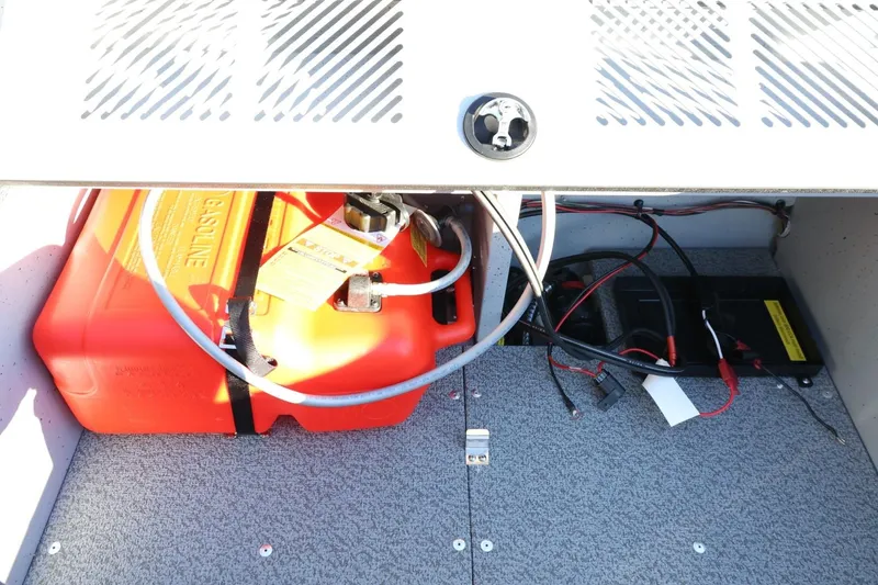 Slide: The Image of 2026 Lund 1600 Fury Tiller boat compartment with red gasoline tank and wiring. - 20