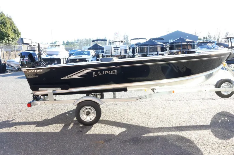 Slide: The Image of 2026 Lund 1600 Fury Tiller boat on trailer in outdoor setting. - 5