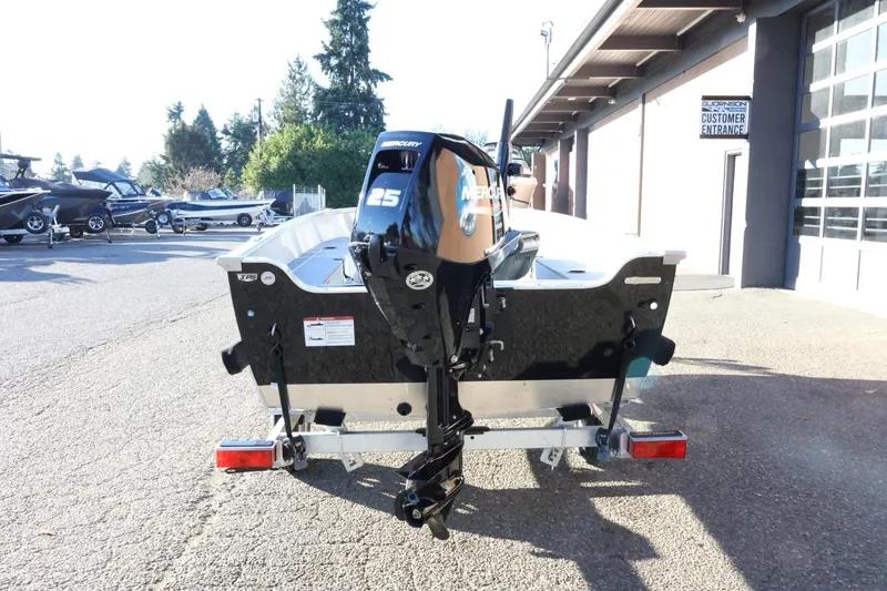 Slide: The Image of 2026 Lund 1600 Fury Tiller boat with Mercury 25 engine, parked outdoors. - 7