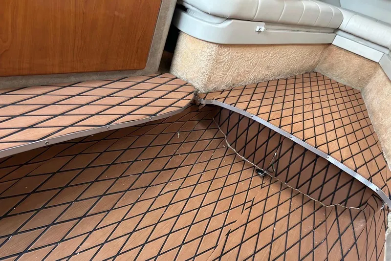 Slide: The Image of Damaged flooring in 2006 Formula 330 Sun Sport boat interior, showing lifted panels and seating area. - 12