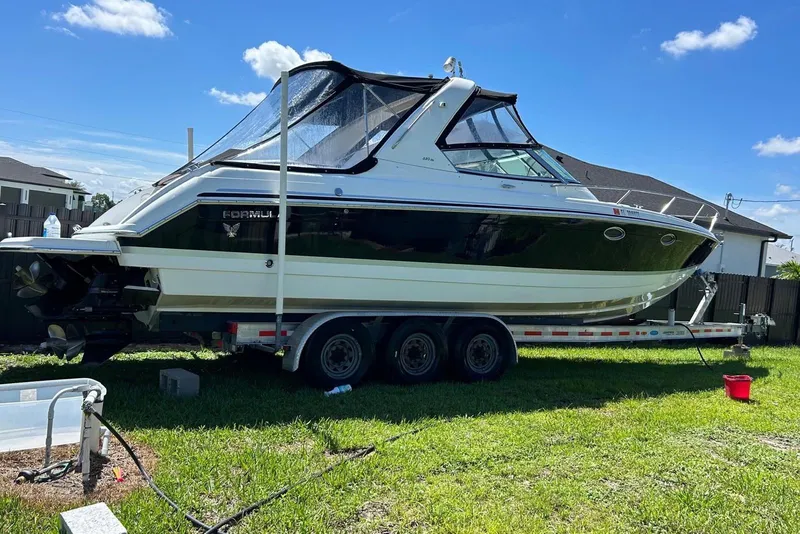 Slide: The Image of 2006 Formula 330 Sun Sport boat on trailer, parked on grass under blue sky. - 3