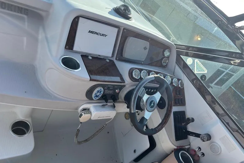 Slide: The Image of 2006 Formula 330 Sun Sport boat dashboard with steering wheel and Mercury controls. - 7