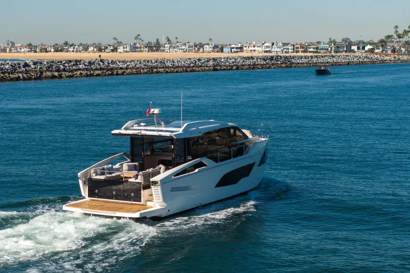 Slide: The Image of 2026 Absolute 48 Coupe yacht cruising near a coastal shoreline. - 11