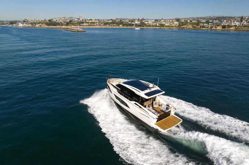 Slide: The Image of Luxury Absolute 48 Coupe yacht cruising near coastline, 2026 model. - 12