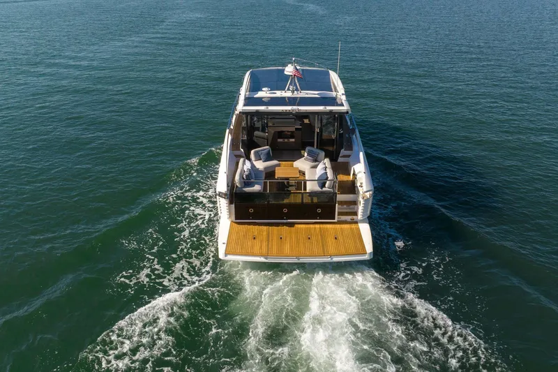 Slide: The Image of 2026 Absolute 48 Coupe yacht cruising on open water, rear view. - 13