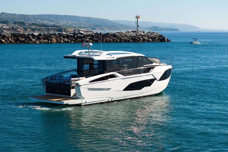 Slide: The Image of 2026 Absolute 48 Coupe yacht cruising near rocky coastline. - 3