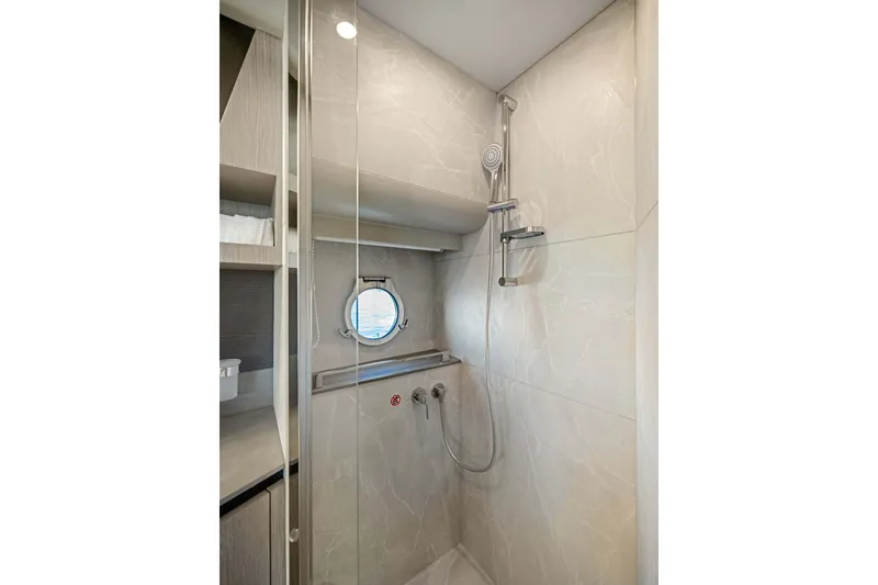 Slide: The Image of Luxurious shower in 2026 Absolute 48 Coupe yacht, featuring modern fixtures and porthole window. - 32