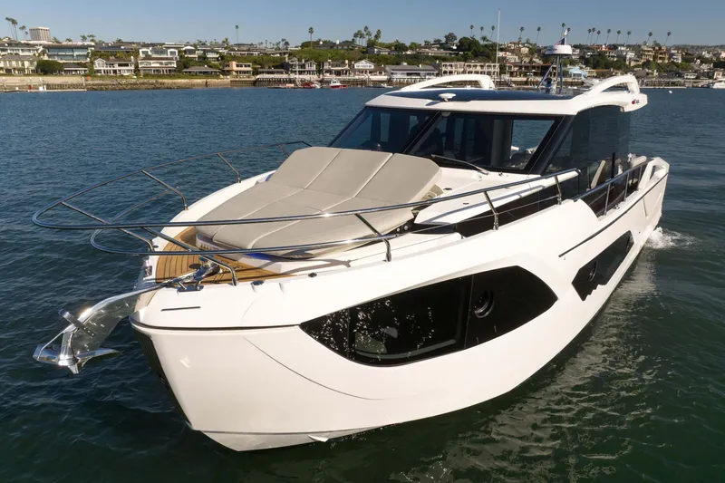 Slide: The Image of 2026 Absolute 48 Coupe luxury yacht cruising in a scenic coastal area. - 5