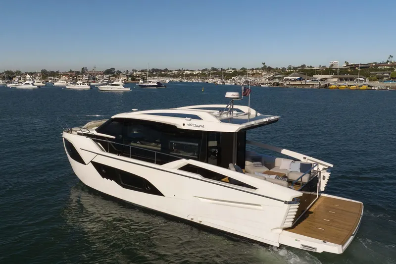 Slide: The Image of 2026 Absolute 48 Coupe luxury yacht cruising in a scenic harbor. - 7