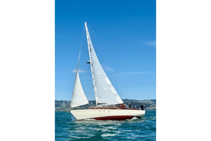 The Image of Vintage 1978 Vindo 50 sailboat cruising on a sunny day with clear blue skies. - 1