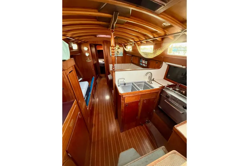 Slide: The Image of Interior of 1978 Vindo 50 sailboat with wooden finishes and compact kitchen area. - 12