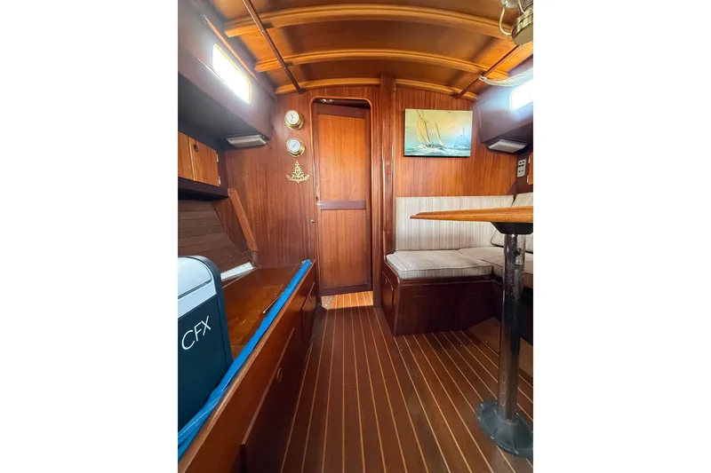 Slide: The Image of Interior of a 1978 Vindo 50 sailboat with wooden furnishings and seating area. - 13
