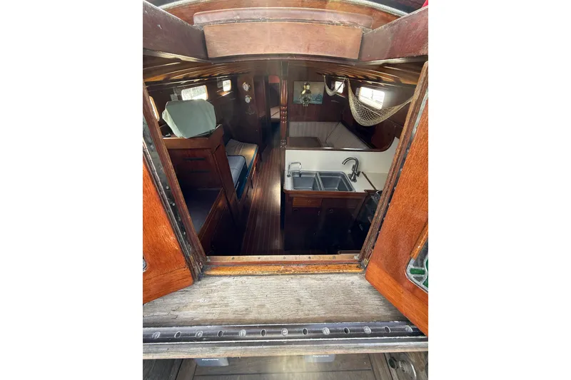 Slide: The Image of Interior view of a 1978 Vindo 50 sailboat, featuring a cozy cabin and kitchenette. - 14