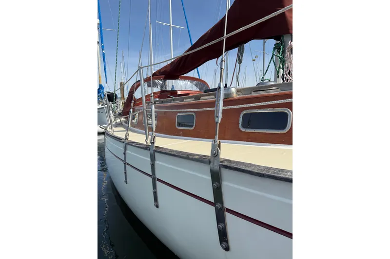 Slide: The Image of 1978 Vindo 50 sailboat with wooden accents and red canopy, docked in marina. - 16