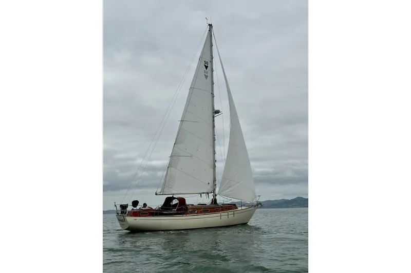 Slide: The Image of 1978 Vindo 50 sailboat on calm waters under cloudy skies. - 19