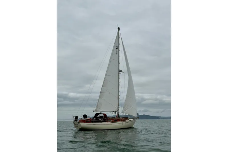 Slide: The Image of 1978 Vindo 50 sailboat on calm waters under cloudy skies. - 2