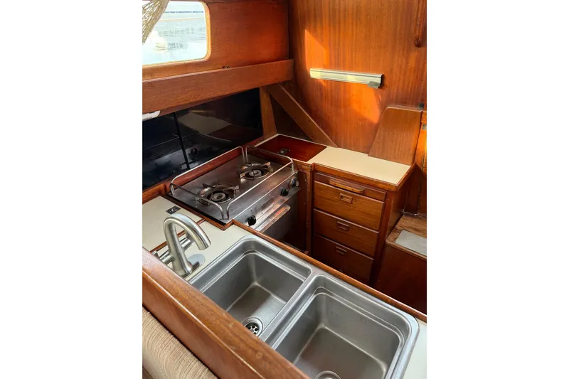 Slide: The Image of 1978 Vindo 50 yacht kitchen with dual sink, stove, and wooden cabinetry. - 8