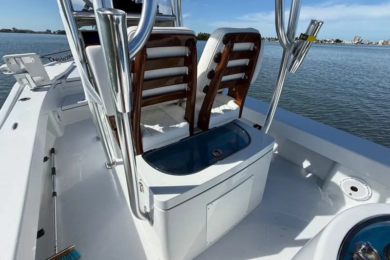 Slide: The Image of 2024 East Cape 25 Hybrid boat interior with seating and storage, on calm water. - 17