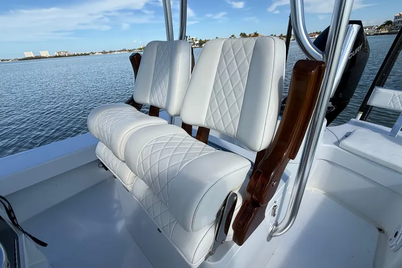 Slide: The Image of 2024 East Cape 25 Hybrid boat with luxurious white seating on a calm water backdrop. - 18