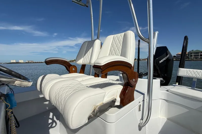 Slide: The Image of 2024 East Cape 25 Hybrid boat with luxurious white seating and Mercury engine. - 19