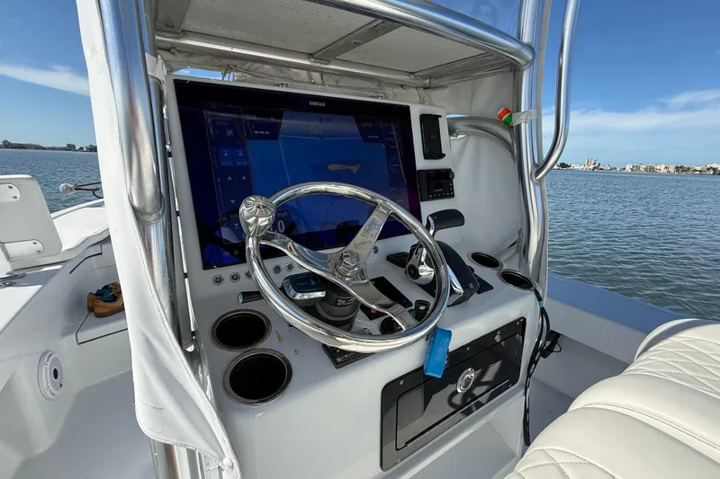 Slide: The Image of 2024 East Cape 25 Hybrid boat dashboard with steering wheel and navigation display. - 21