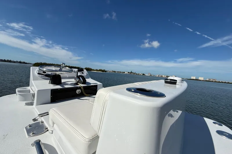 Slide: The Image of 2024 East Cape 25 Hybrid boat on calm water under clear blue sky. - 30