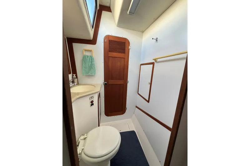 Slide: The Image of Bathroom interior of 2003 Endeavour 36 TrawlerCat, featuring toilet, sink, and wooden door. - 11