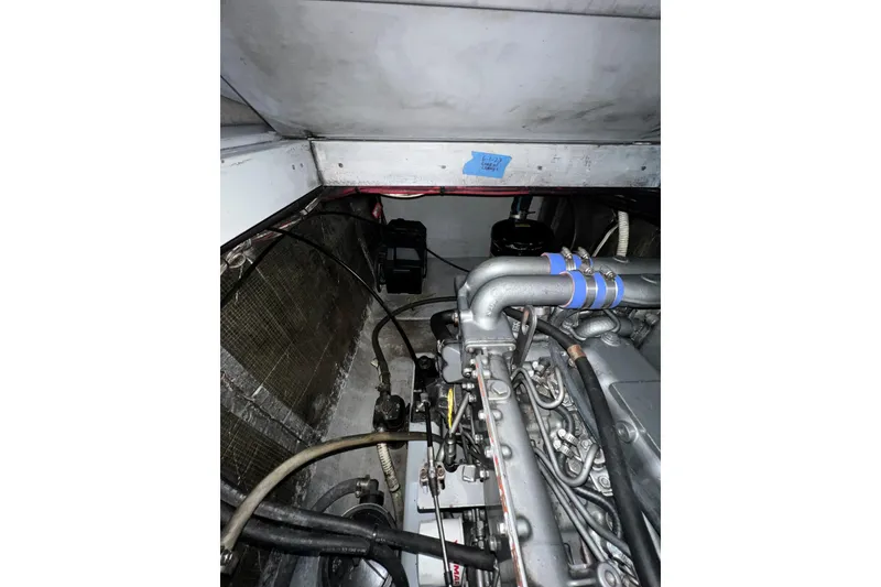 Slide: The Image of Engine compartment of a 2003 Endeavour 36 TrawlerCat, showcasing mechanical components and wiring. - 16