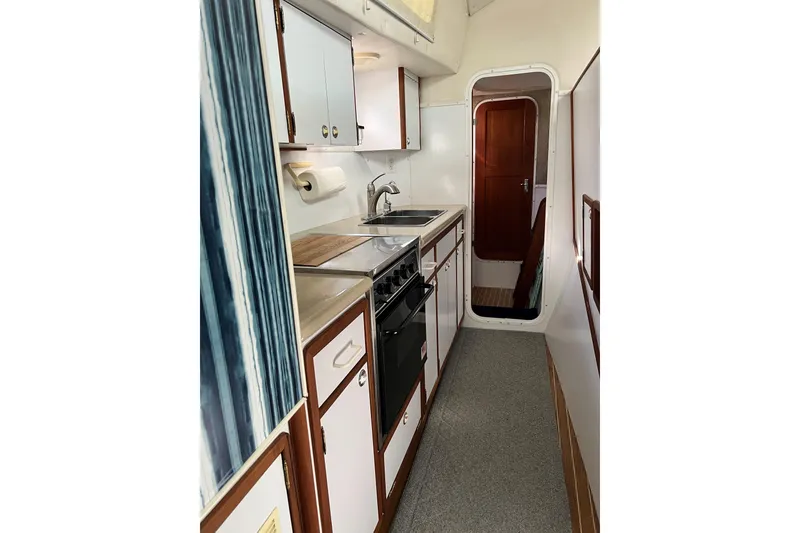 Slide: The Image of 2003 Endeavour 36 TrawlerCat kitchen with stove, sink, and storage cabinets. - 8