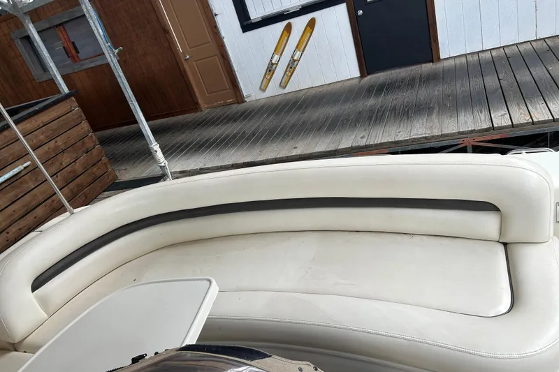Slide: The Image of White leather seating on a 2004 Sea Ray 420 Sundancer boat docked at a wooden pier. - 10