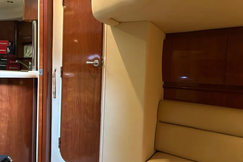 Slide: The Image of Interior of 2004 Sea Ray 420 Sundancer with wooden cabinetry and beige seating. - 13