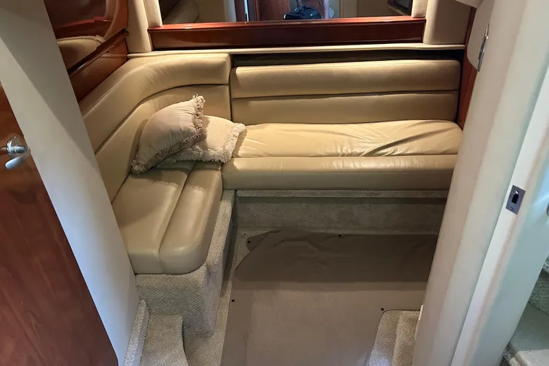 Slide: The Image of Interior of 2004 Sea Ray 420 Sundancer with beige leather seating and decorative pillow. - 14
