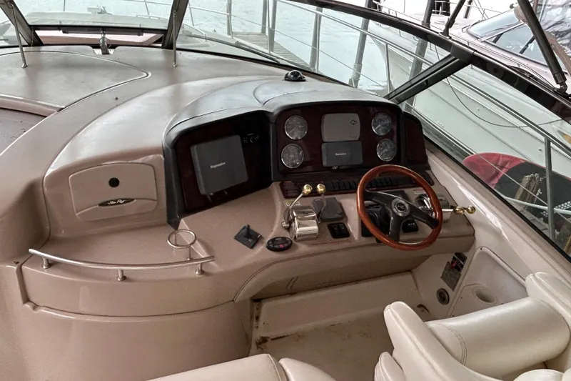 Slide: The Image of 2004 Sea Ray 420 Sundancer helm with steering wheel and navigation controls. - 23