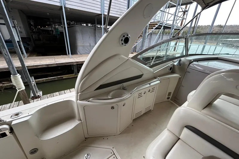 Slide: The Image of 2004 Sea Ray 420 Sundancer interior with seating and storage, docked at marina. - 25